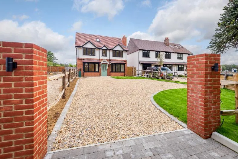 Gated entrance and gravel driveway to the two homes