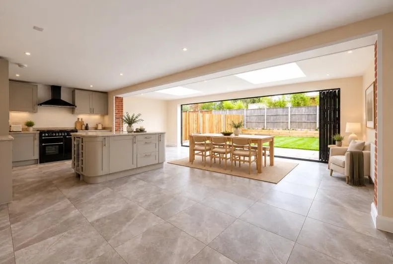 Open-plan kitchen and dining area with bi-folding doors open to the garden